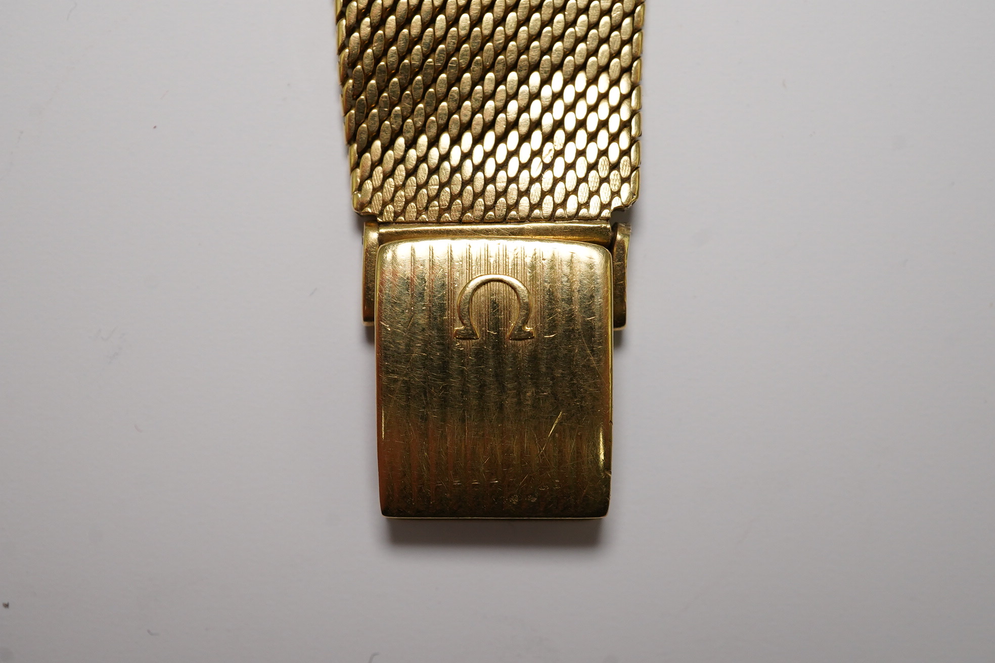 A gentleman's early 1960's 18ct gold Omega De Ville automatic dress wrist watch, on integral Omega 18ct gold mesh link bracelet